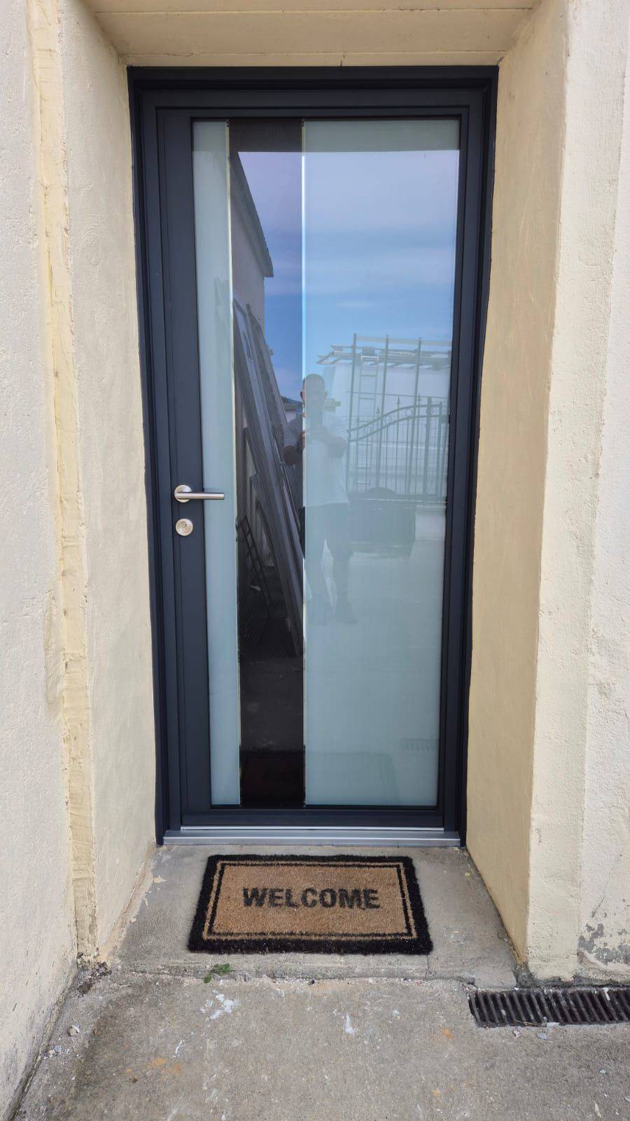 Pose d'une porte d'entrée vitrée en aluminium dépoli à Morestel