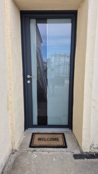 Pose d'une porte d'entrée vitrée en aluminium dépoli à Morestel